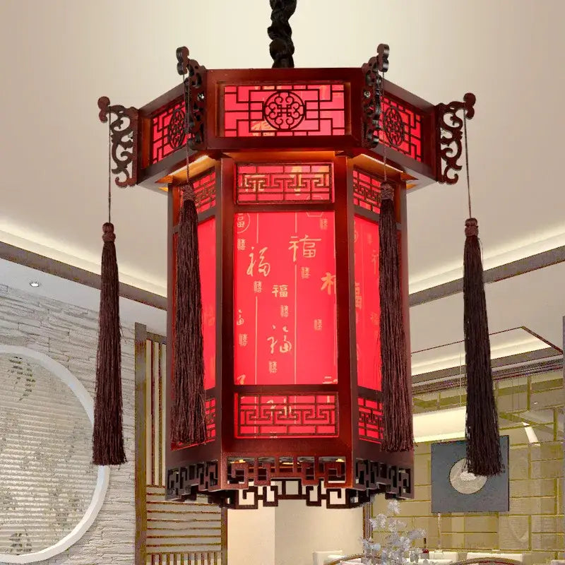 Red traditional chinese carved bamboo lantern pendant light with dark wood framing and golden calligraphy panels for dining room