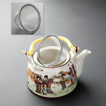 Traditional Chinese white porcelain tea pot with colorful scene illustration, yellow handle, and matching metal strainer