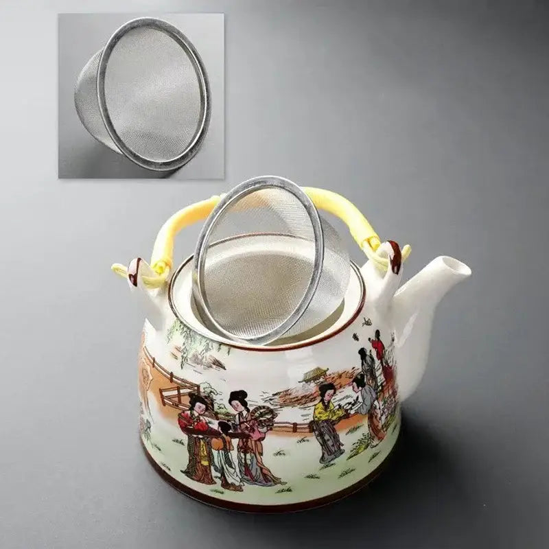 Traditional Chinese white porcelain tea pot with colorful scene illustration, yellow handle, and matching metal strainer