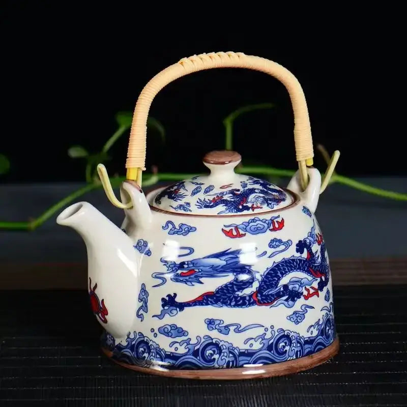 Traditional Chinese white porcelain tea pot with blue and red dragon motifs and woven bamboo handle for dining decor