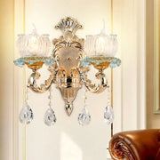 Traditional gold crystal wall sconce with e12 clear glass candle shades and dangling crystal teardrop pendants for restaurant lighting
