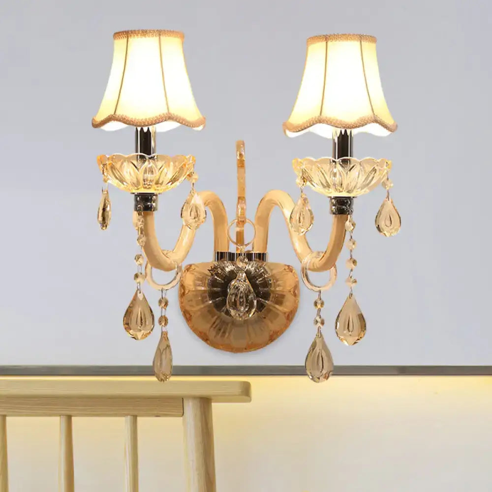 Traditional gold crystal wall sconce with fabric shade and teardrop crystals for elegant bedroom lighting