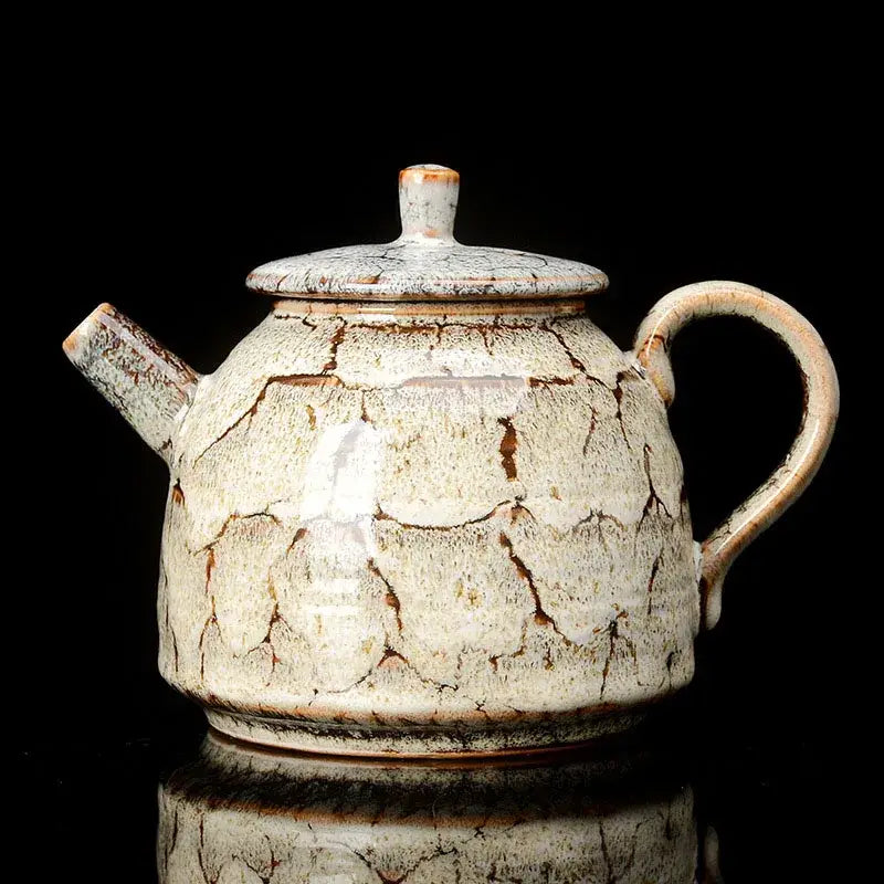 A rustic pink and brown crackle ceramic kung fu tea pot with rounded body and curved handle for dining room decorbites teaware