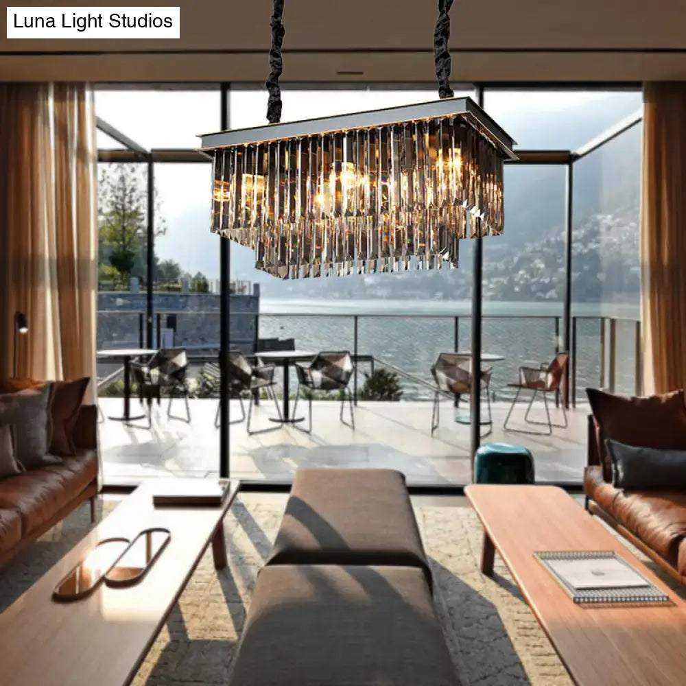 A modern smoke gray light fixture with cascading crystal prisms and a metallic frame for dining room use