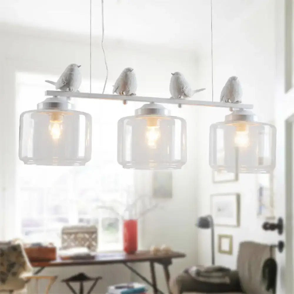 White ceramic bird pendant light with clear glass shades and metallic accents ideal for dining room décor