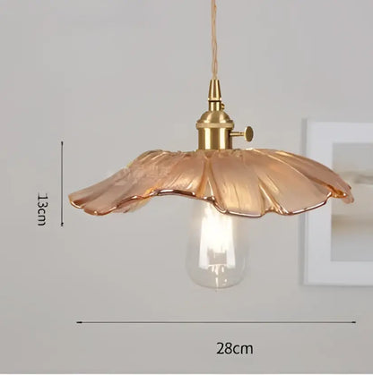 A delicate golden-toned glass pendant light with petal-shaped shade and exposed bulb complements decorbites blue glass pendant lights