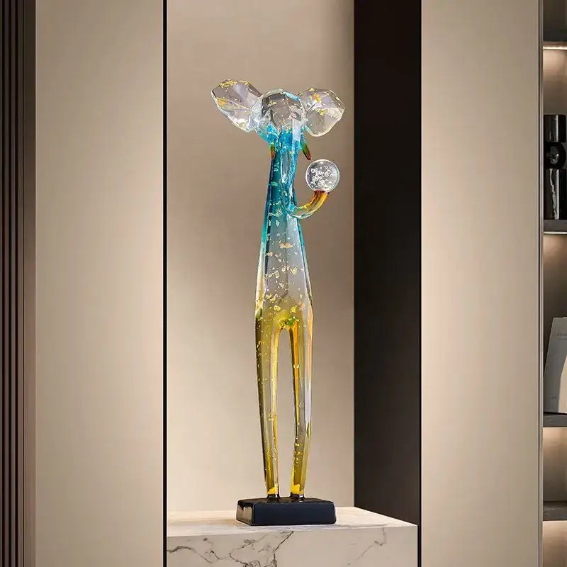 Translucent glass floor decoration sculpture of a stylized deer with blue and yellow gradient colors holding a clear orb