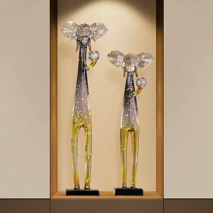 Two translucent glass elephant floor decoration figurines in blue to yellow gradient with crystal ears and gemstone trunks