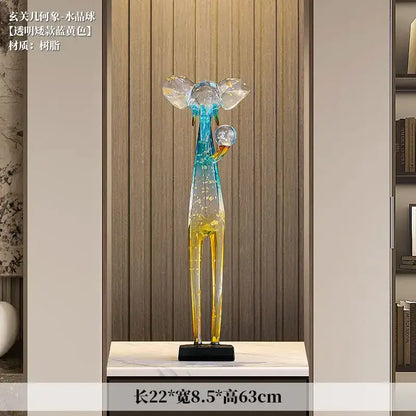 Translucent blue and yellow resin elephant floor decoration sculpture with crystal-like headpieces holding spheres