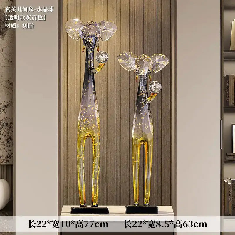 Two translucent amber resin giraffe sculptures with crystal ears and decorative spheres complement modern elephant floor decoration