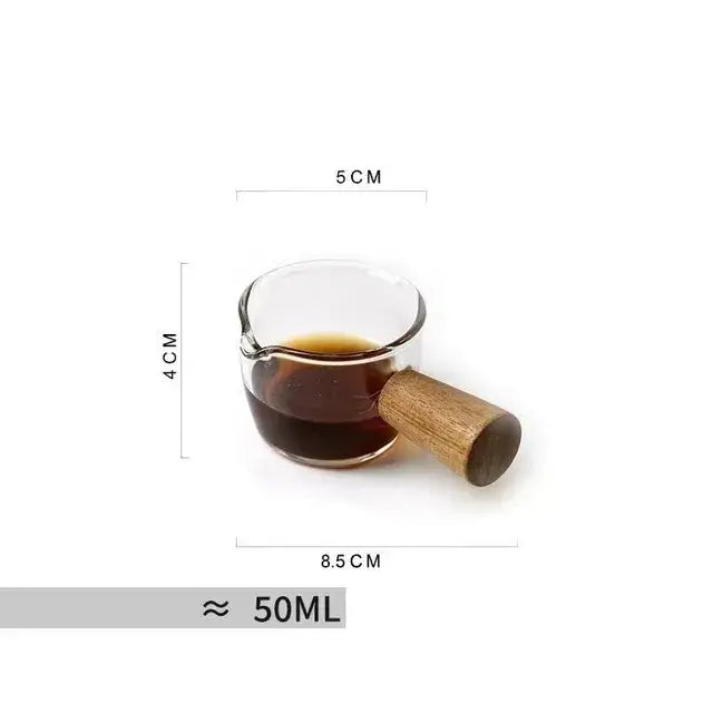 A clear glass coffee mug with a wooden handle filled with dark liquid showcasing heat resistant design