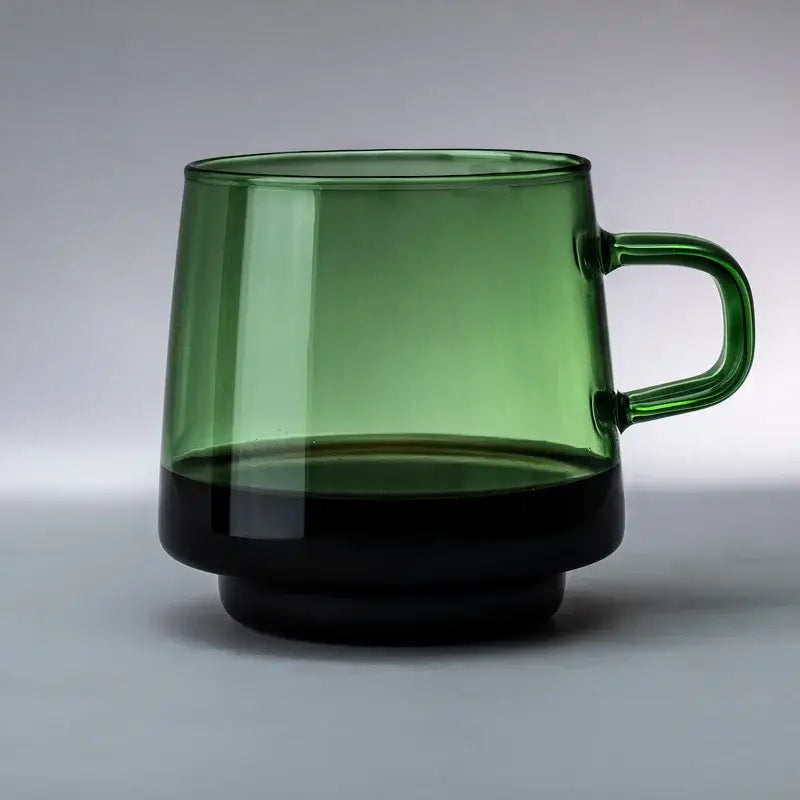 A sleek translucent green glass coffee mug with a black base and handle, heat resistant and ideal for kitchen use