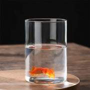 A clear transparent glass hydroponic vase with two vibrant orange goldfish for home office or wedding table decor