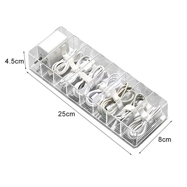 Transparent plastic cable storage box with clear acrylic compartments holding white charging cables and adapters for decorbites cable storage