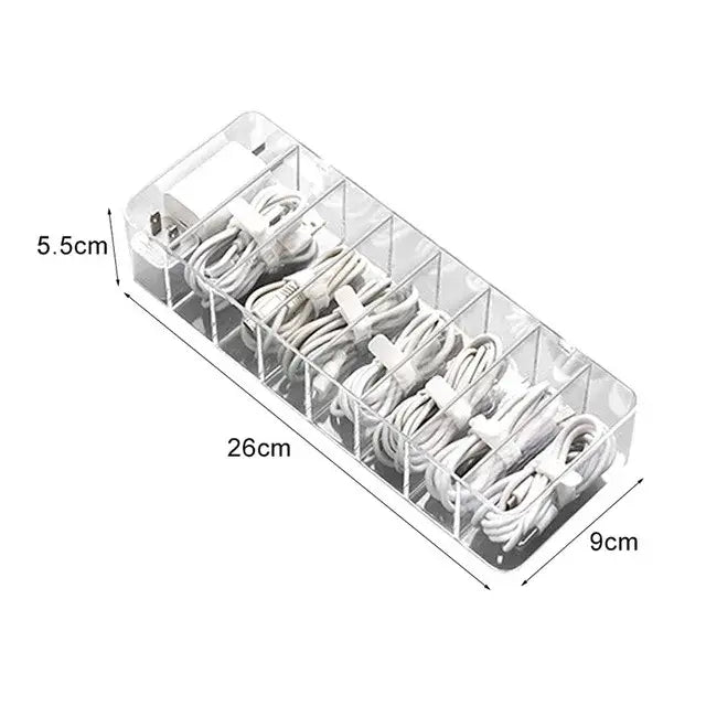 Transparent clear acrylic cable storage box with multiple compartments holding white charging cords by decorbites cable storage