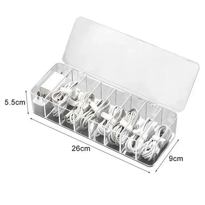 Transparent plastic cable storage box with multiple compartments holding white charging cables and adapters for office desk organization decorbites cable storage