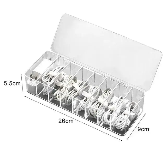 Transparent plastic cable storage box with multiple compartments holding white charging cables and adapters for office desk organization decorbites cable storage