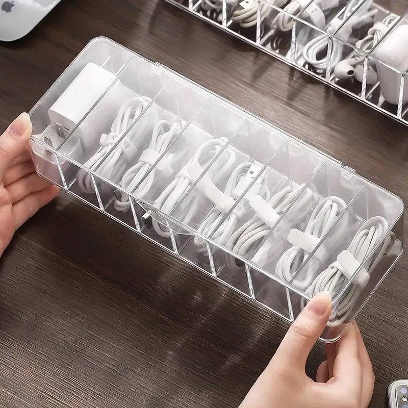Transparent plastic cable storage box with multiple compartments holding neatly coiled white charging cords decorbites cable storage