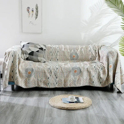 Beige quilted cotton sofa throw blanket with geometric and circular patterns in gray beige and muted orange tones
