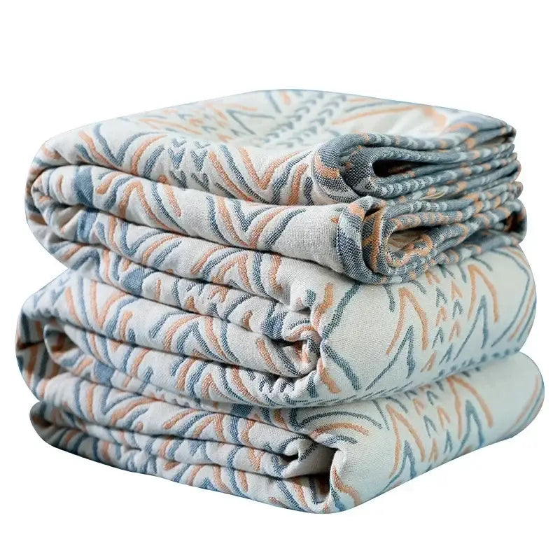 Stack of cotton tribal beige quilted sofa throw blankets with muted blue and peach wavy patterns for living room use