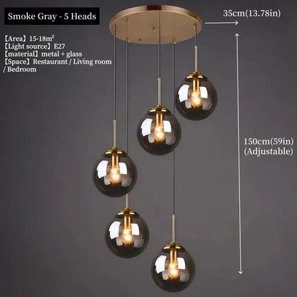 Smoke gray glass globe pendant light with brass accents and adjustable height in polished steel for dining room use