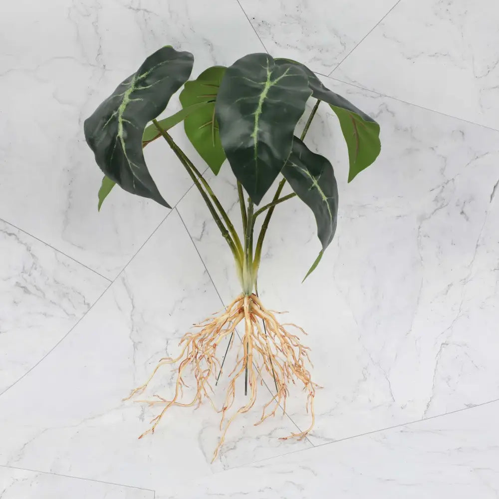 Artificial alocasia plant with dark green leaves and light veins in a tropical plant wall set for living room decor