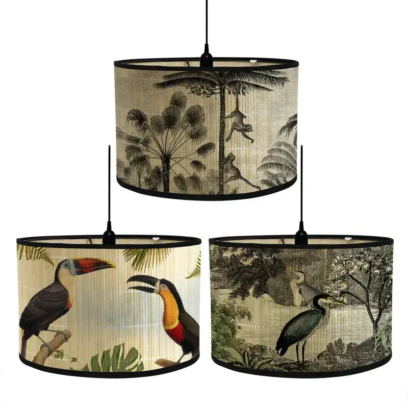 Three cylindrical decorbites bamboo pendant light shades with tropical bird print on beige fabric background