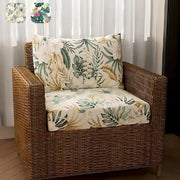 Wicker armchair with tropical green and cream brushed polyester microfiber cushions featuring leaf patterns