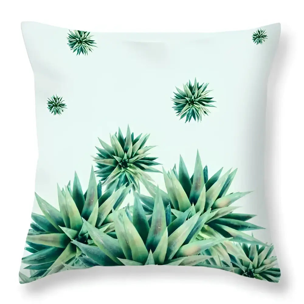 A square throw pillow with a vibrant green leaves decorative cactus print on a soft mint background for home decor