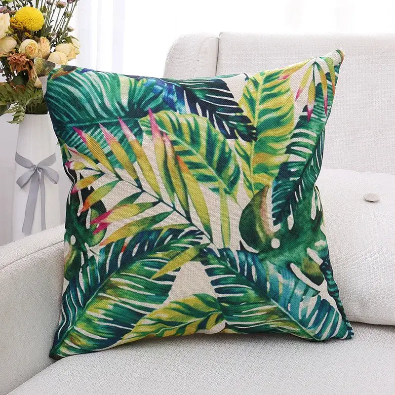 Tropical green plant leaves linen cushion cover with vibrant tropical leaf pattern in green yellow and pink hues on fabric