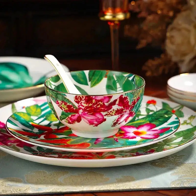 A vibrant floral-patterned ceramic bowl with gold rim featuring pink orchids in the green leaf collection porcelain tea set