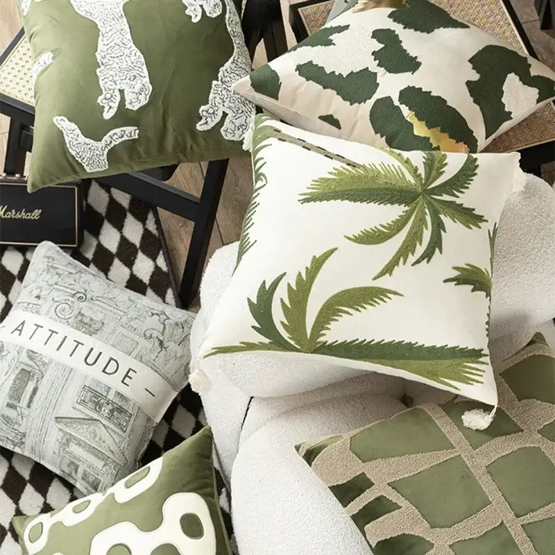 White cushion cover with embroidered green palm fronds and tassels in tropical olive and cream patchwork design
