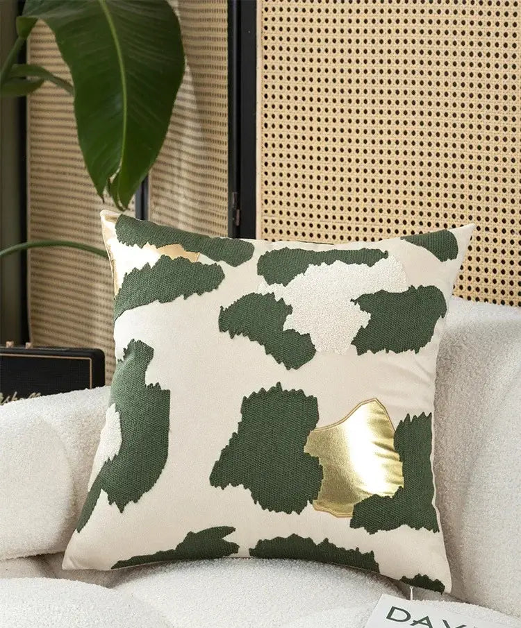 Cream-colored cushion cover with modern leopard print embroidered patchwork in dark green and metallic gold for living room