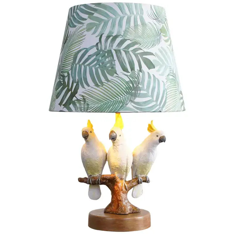 Tropical parrot desk lamp with three white cockatoo figurines on a tree branch base and green leaf shade decorbites cartoon parrot