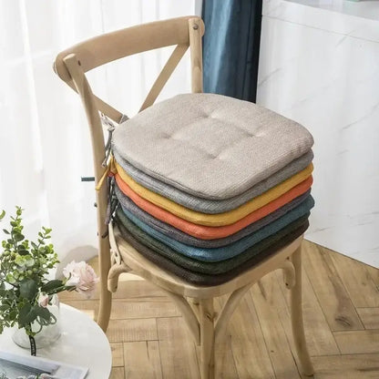 Stack of tufted beige textured fabric dining chair cushions in neutral warm tones for decorbites dining chair use