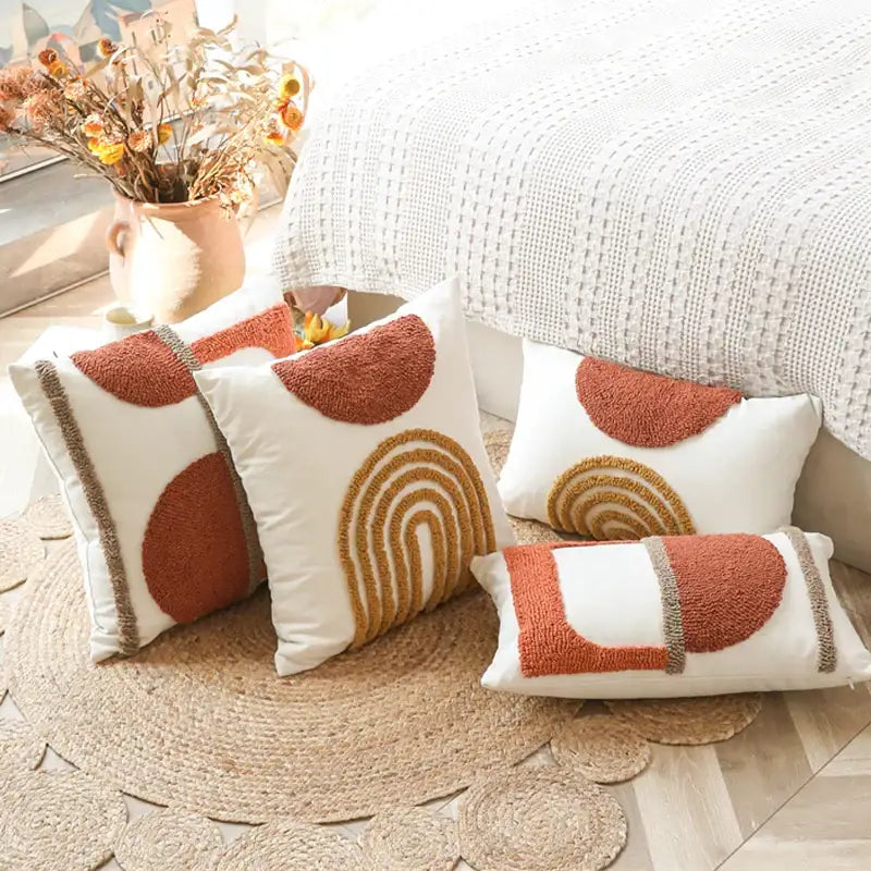 White throw pillows with textured earth-toned geometric embroidery in rust and mustard yellow cushion cover decorbites geometric tufted