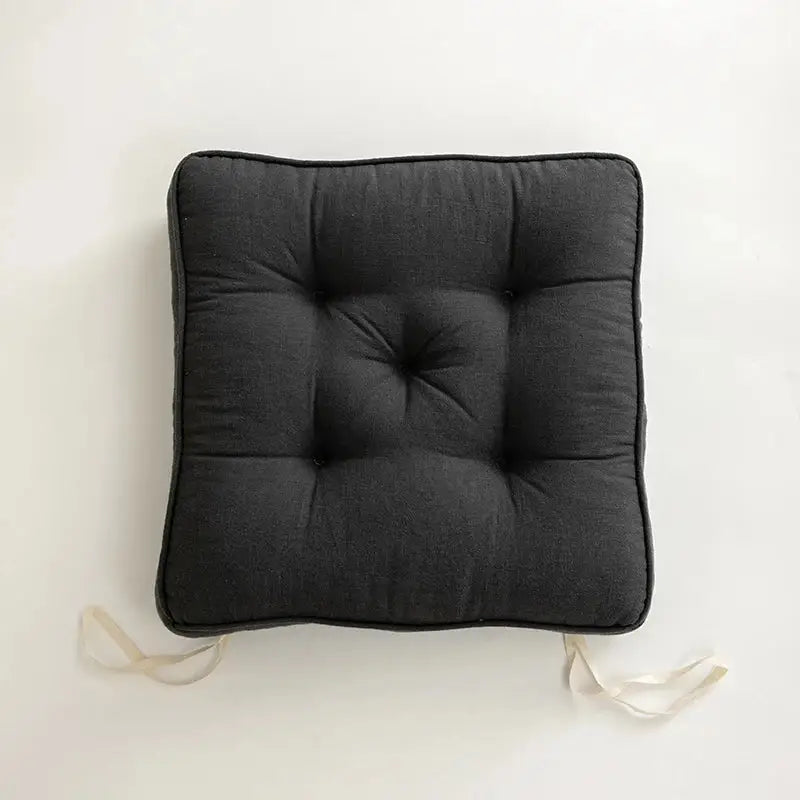 Black tufted button cushion with fabric ties by decorbites, perfect for living room decor in terracotta cream and olive