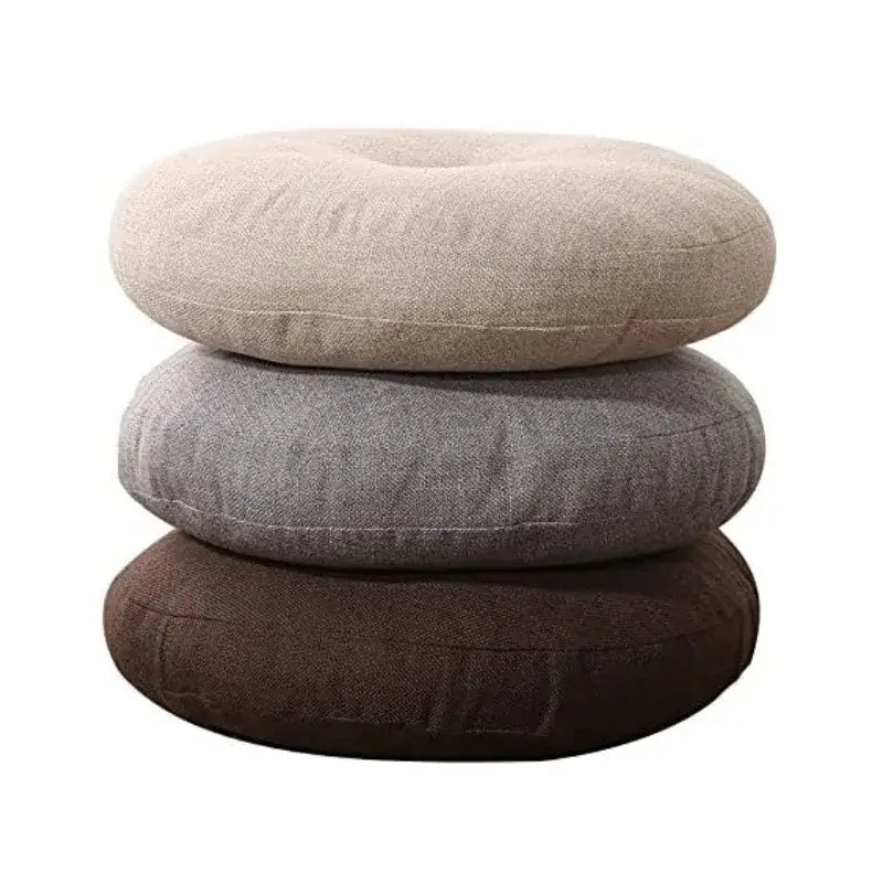 Stacked tufted grey linen floor pillow seating cushions in beige gray and brown textured fabric for living room use