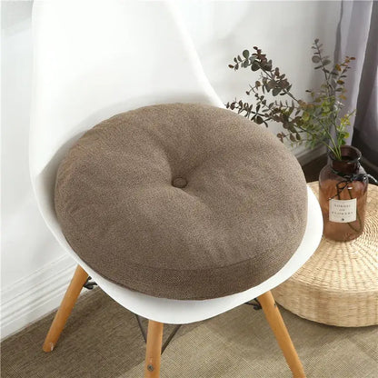 Brown textured fabric round seating cushion with central button detail for living room floor pillow seating pouf