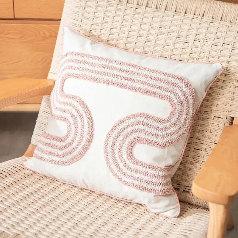 A soft white cotton loop tufted cushion cover with decorative pink and cream swirling pattern for living room decorbites
