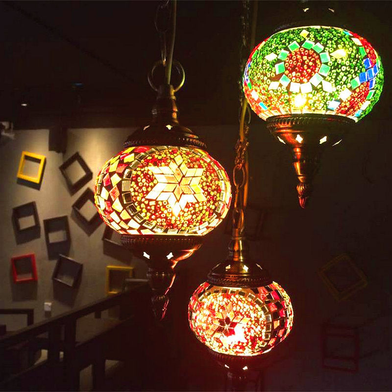 Mosaic globe pendant light with vibrant colors and intricate patterns, featuring a brass or bronze finish.
