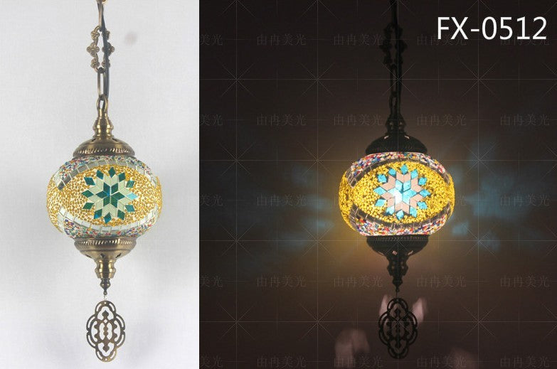 Mosaic globe pendant light with intricate starburst pattern and dangling metal ornament, featuring a mix of green, yellow, blue, and gold colors.