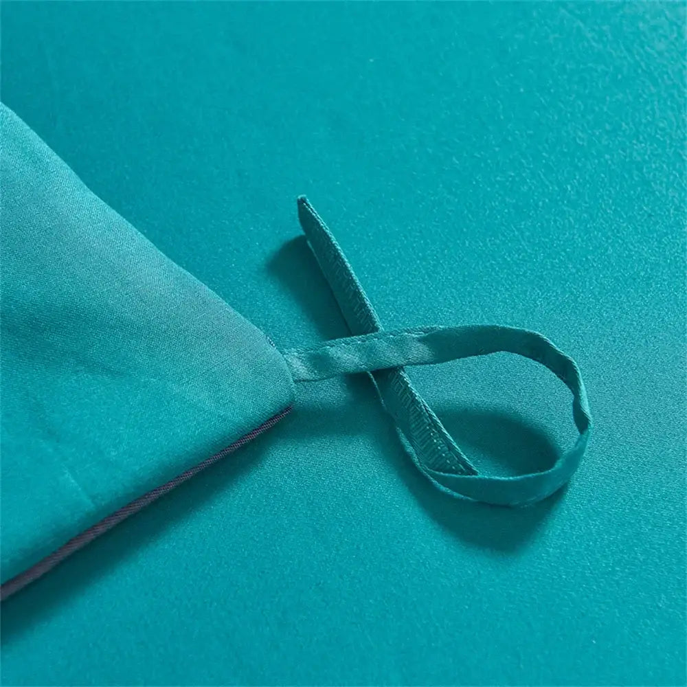 Teal satin ribbon loop with sheen and fine texture on turquoise blue satin jacquard embroidery bedding set decorbites
