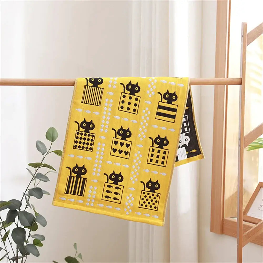 Bright yellow decorbites cotton gauze face towel with playful black cats in boxes for hand and face use