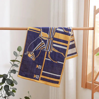 Navy blue and gold horse patterned decorbites cotton gauze face towel hanging on wooden rack for hand and face use