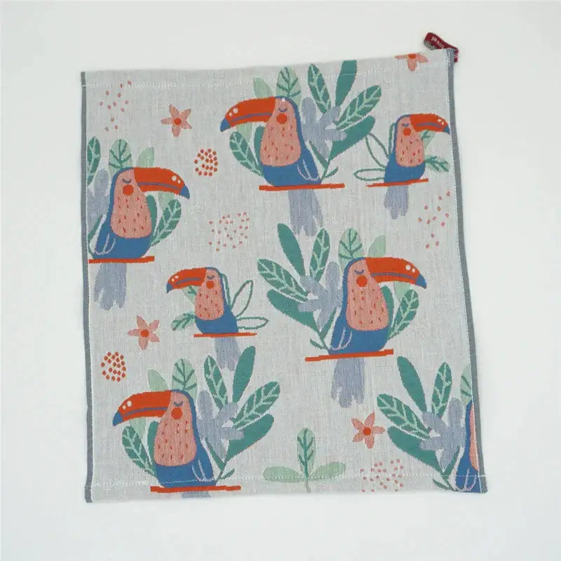 A light gray decorbites cotton gauze face towel with playful cartoon toucan pattern and green leaves for bathroom use