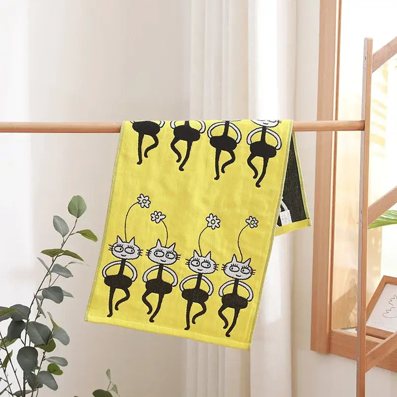 Bright yellow decorbites cotton gauze face towel with playful black and white cartoon cat ballet patterns and flowers