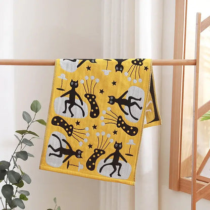 A vibrant yellow cotton gauze hand towel with playful black cat illustrations from decorbites face towel set