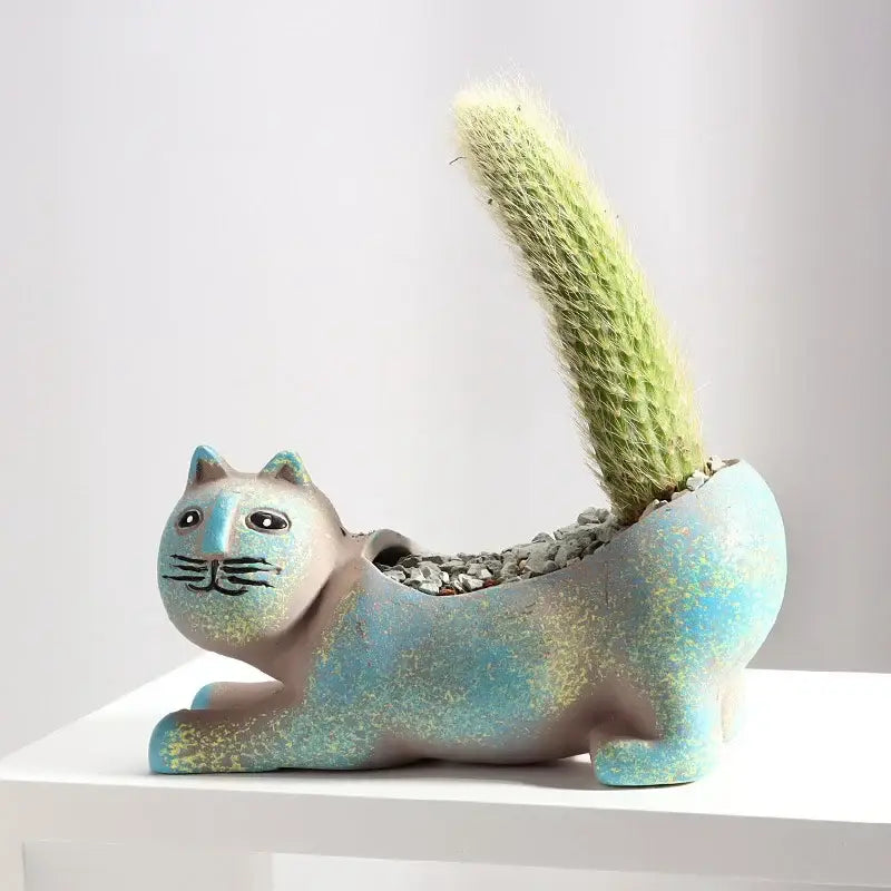 A turquoise ceramic cat succulent plant pot with distressed glaze featuring a green cactus for living room decor