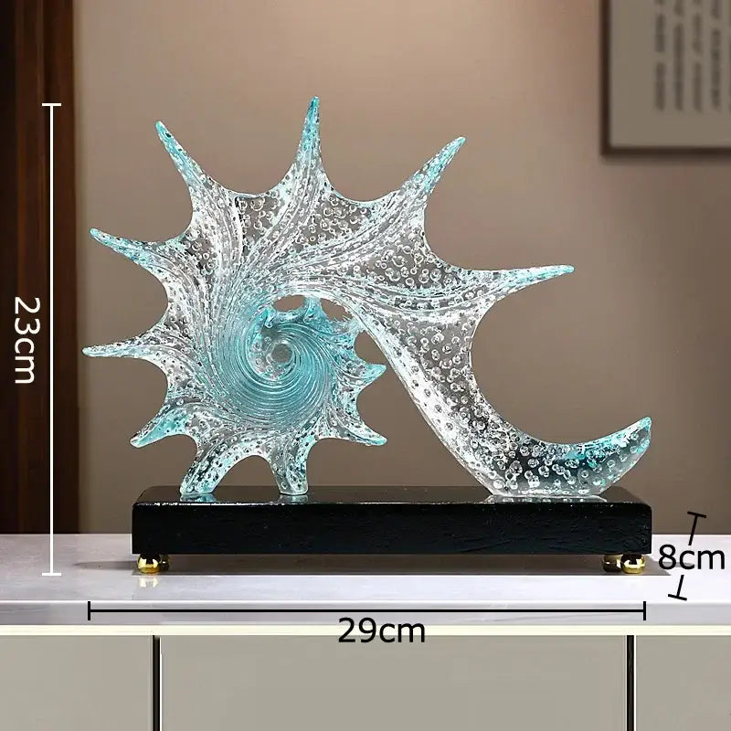 A translucent turquoise bubble conch sculpture with spiral and bubble texture mounted on a black base for decor